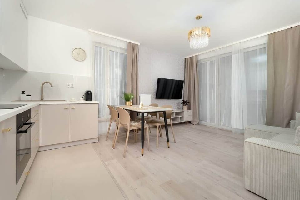 Spacious and bright living room with a large dining table and elegant lighting, offering a comfortable space for meals at the apartment on Słoneczna 1A.