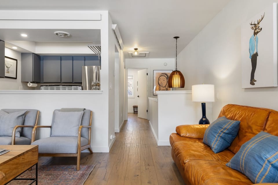 Sink into the rich leather sofa with your favorite drink as warm light fills this thoughtfully designed open-plan space.