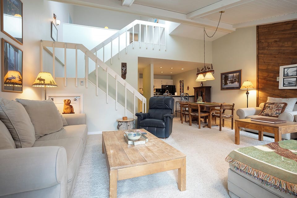 Unwind in this spacious living room featuring vaulted ceilings, cozy seating, and rustic mountain charm perfect for your getaway.