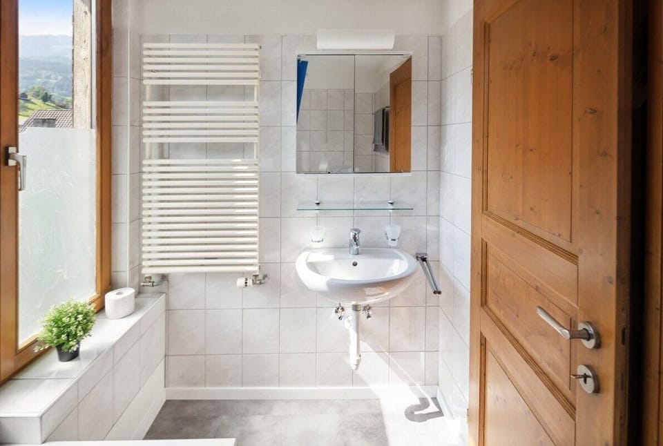 Badezimmer mit Handtuchheizkörper und Spiegel