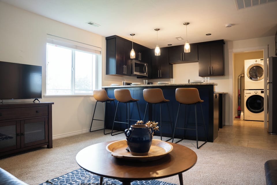 The fully stocked kitchen is open to the living room with 4 barstools for dining