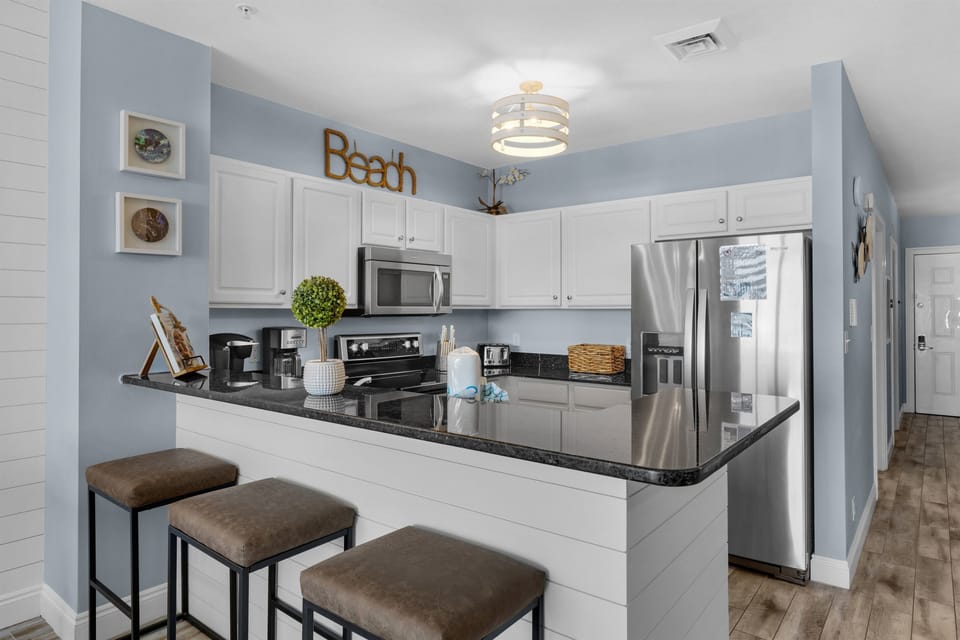 Dining Area - Dine in comfort and style at this elegant table for four, set against a beautiful backdrop of the beach and endless ocean horizons. Includes 3 bar stools for extra seating!