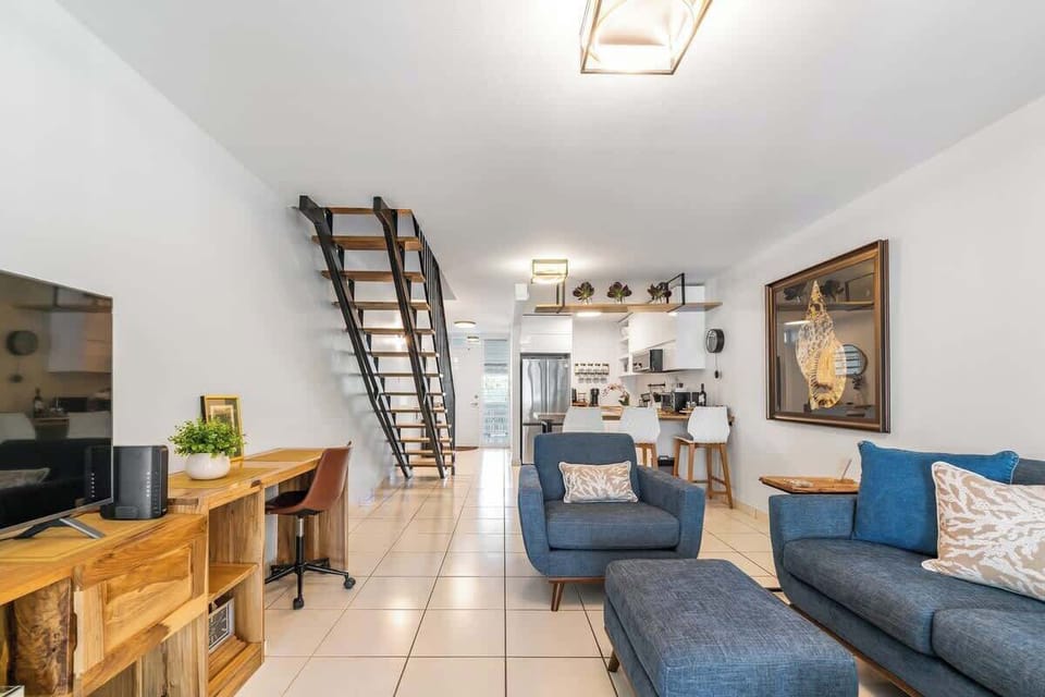 Open-space design with kitchen and dining area to one side, while on the other, leading out to a furnished patio.