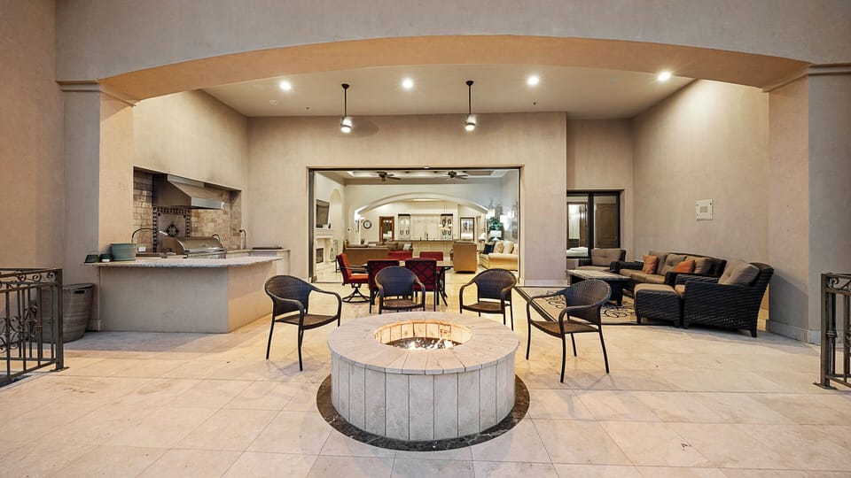 Covered patio with fire pit, outdoor kitchen, and seamless indoor access.