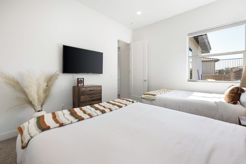 Guest bedroom with TV, and shared nightstand gives everyone their own spot to rest.