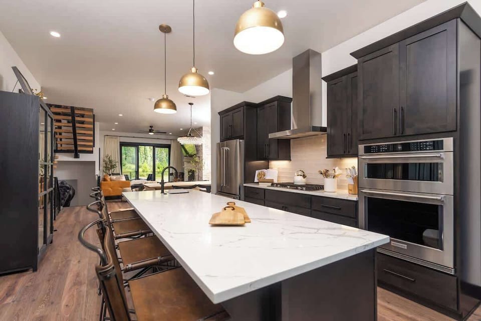 - Cook up mountain memories in this sleek kitchen with quartz island
- Pendant lights warm the space while essential appliances do the work
- Pull up a stool for morning coffee or late night conversation flow

