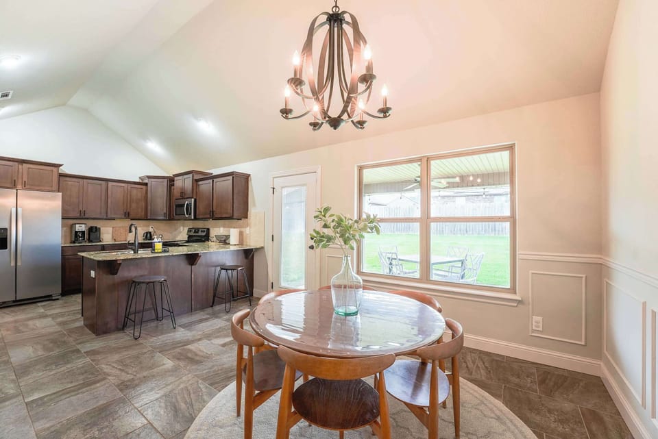 Elegant dining table framed by windows and greenery—a lovely space for shared meals or work‑from‑home meetings.
