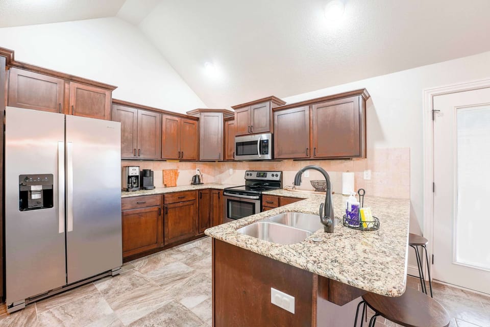 Spacious kitchen equipped with stainless steel appliances and a functional island, ready for your culinary adventures.