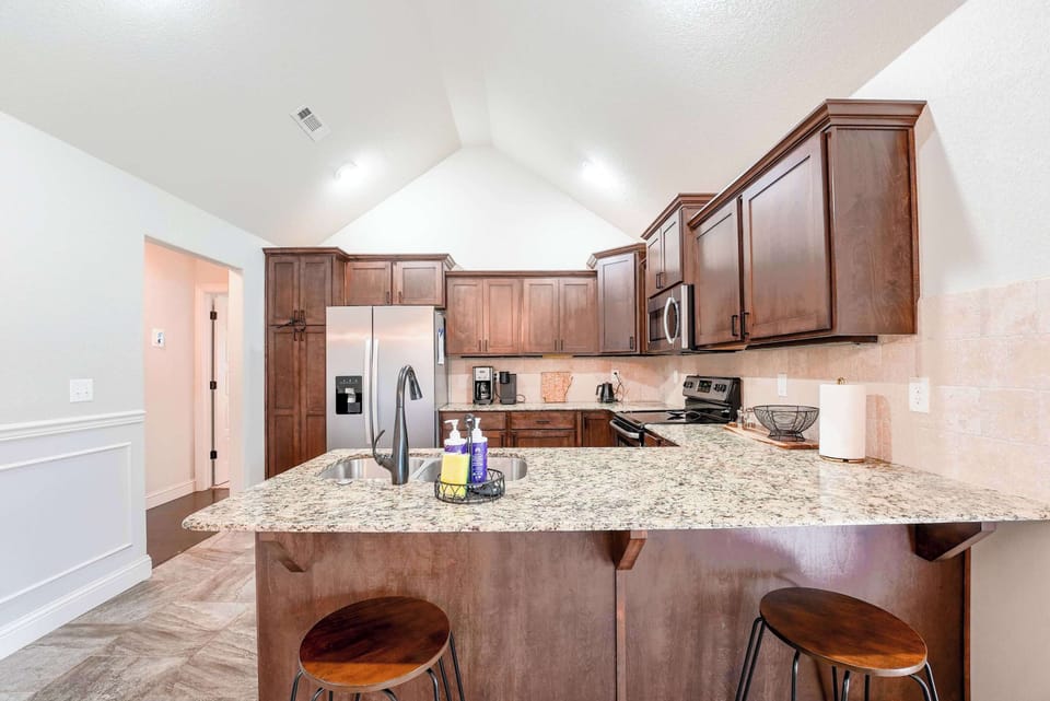Modern kitchen with ample cabinet space and a convenient bar—ideal for casual meals or morning coffee.