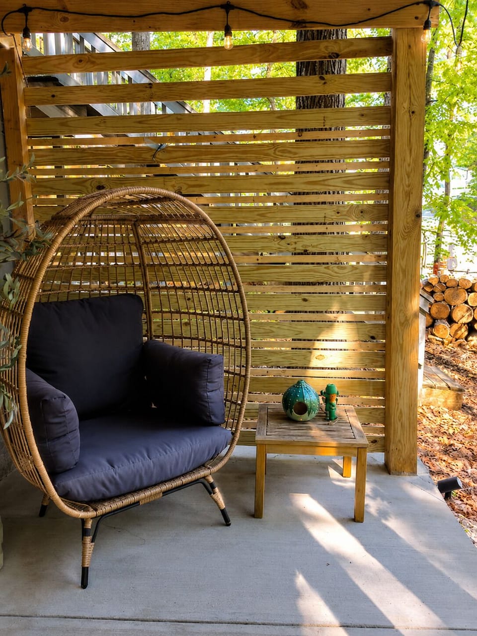Cozy private patio nook with egg chair, string lights, and wooded charm