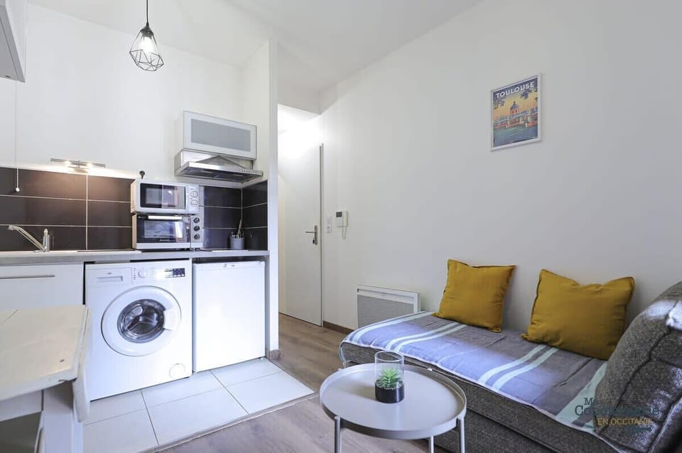 Espace de séjour avec coin salon, tv, coin repas et kitchenette équipée 