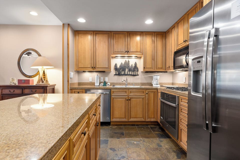 Cook memorable meals in this fully-equipped kitchen with granite counters, stainless appliances, and warm wood cabinetry.