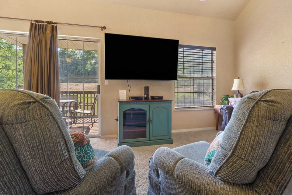 Living room features SmartTV and patio access