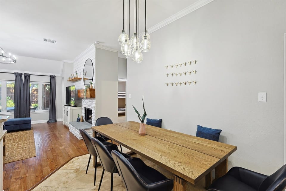 Featuring a wooden dinner table, a bench, and five mid-century modern chairs, this stylish dining area has a restaurant-like feel and enough seating for at least eight guests.