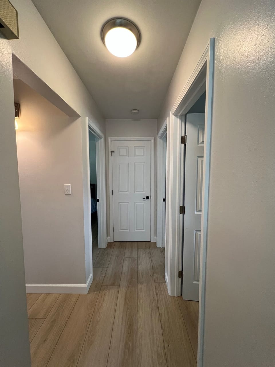Hallway connecting bedrooms and full bathroom