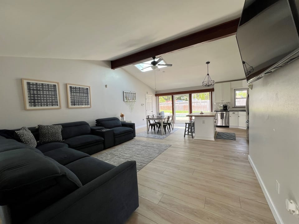 Bright, airy great room with comfortable seating, dining space, and seamless access to the backyard and pool.