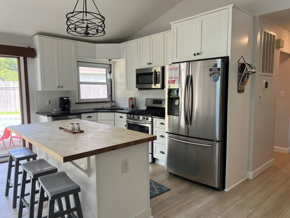 Enjoy a fully stocked, sun-filled kitchen with a large island for meals, coffee bar, and everything you need for a comfortable stay.