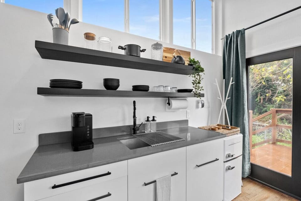 Hanging rack to the right of the kitchen perfect for any small bags, coats, or personal items