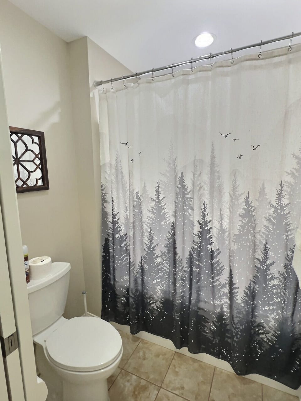 Forest-themed shower curtain in the guest bathroom.