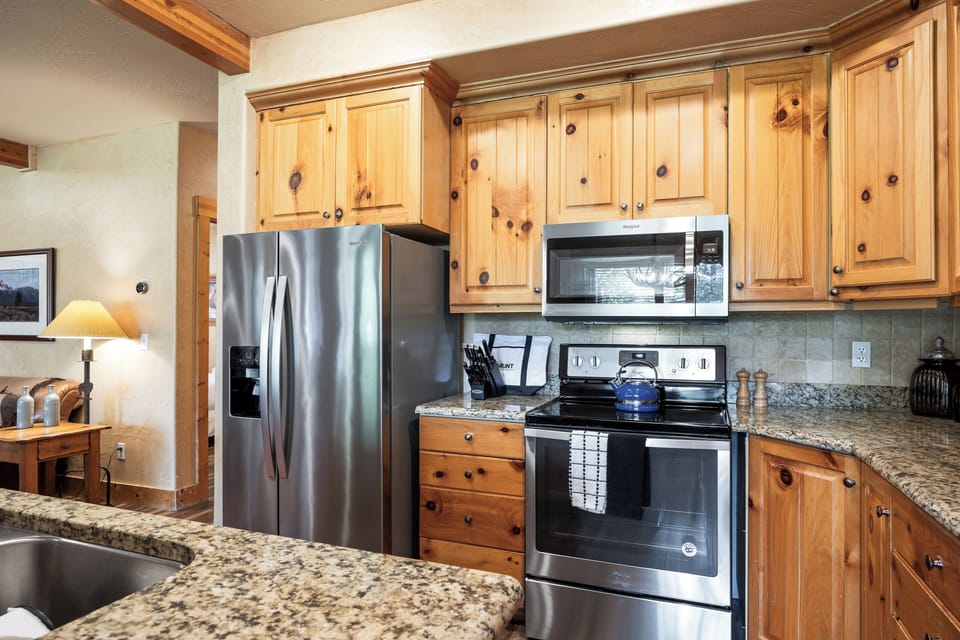 - Stainless steel fridge and oven with granite counters  
- Rustic wood cabinets bring mountain lodge design  
- Fully equipped for home cooked meals with ease