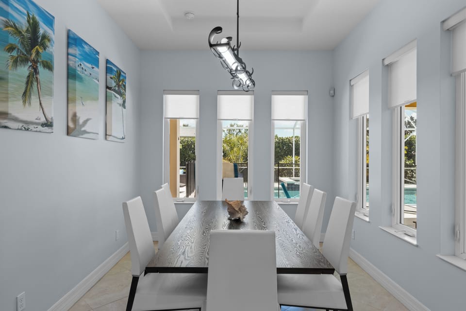 The dining table has seating for 8 people and overlooks the pool area.