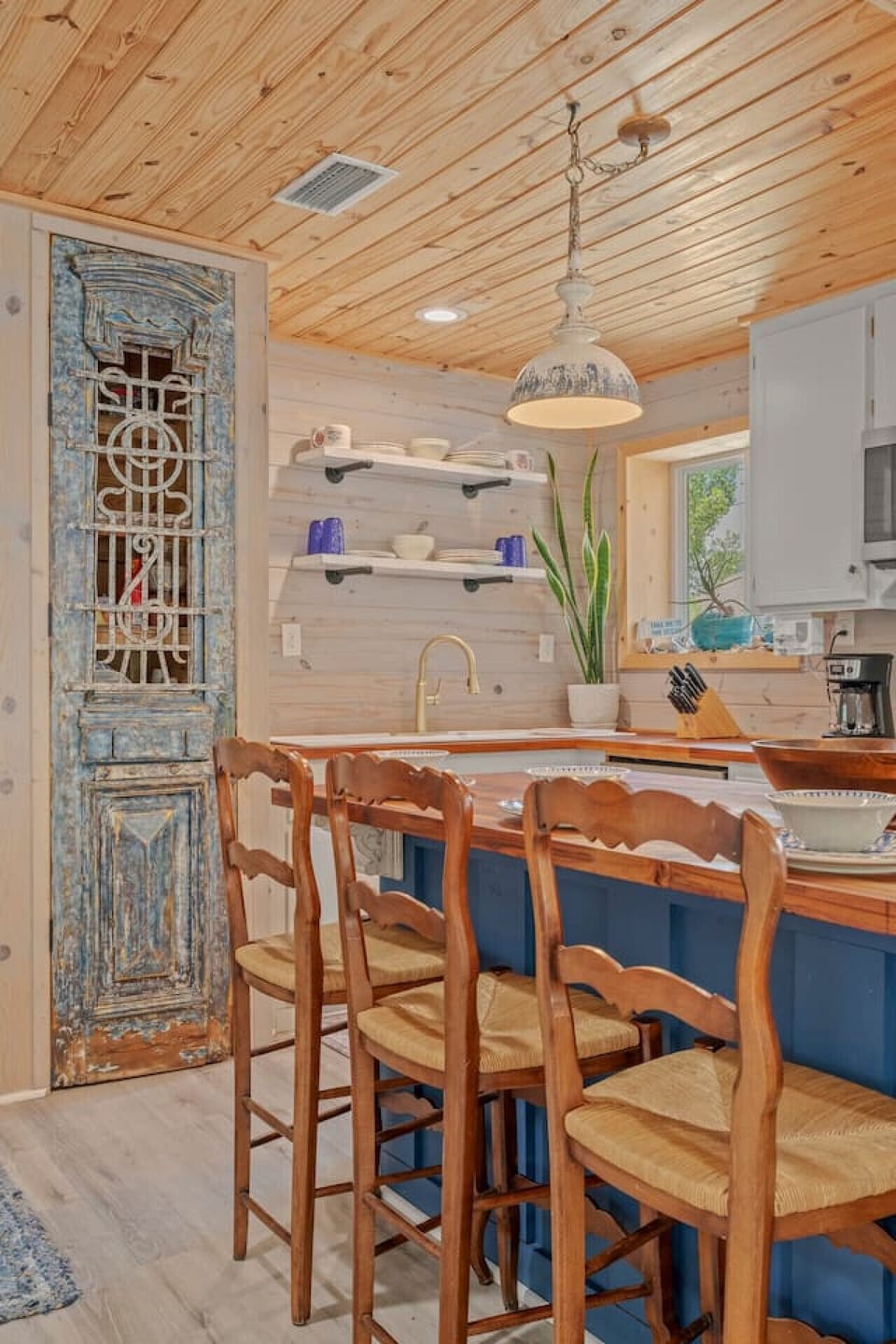 A stylish kitchen island with three high-top chairs, accented by lovely plant decor, creating a perfect spot for casual dining or conversation.