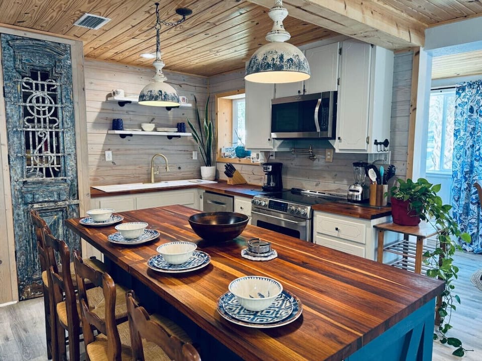 A stylish kitchen island with three high-top chairs, accented by lovely plant decor, creating a perfect spot for casual dining or conversation.