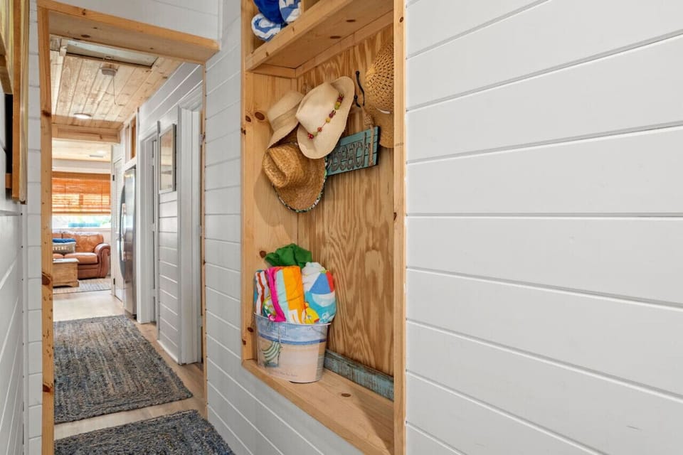 A cozy hallway with shiplap walls and a nook to hang your things, bringing a coastal charm to the space.