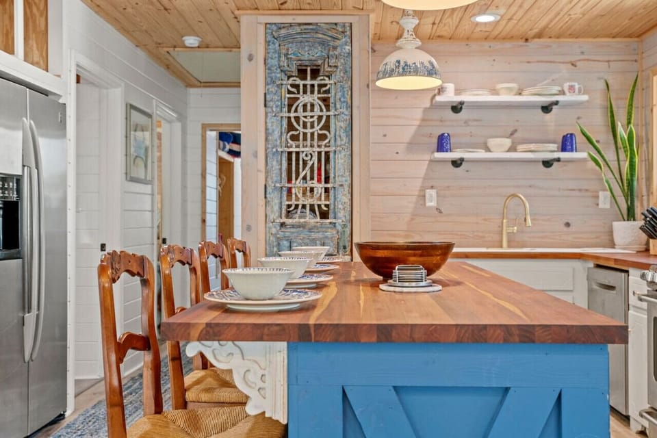 A stylish kitchen island with three high-top chairs, accented by lovely plant decor, creating a perfect spot for casual dining or conversation.