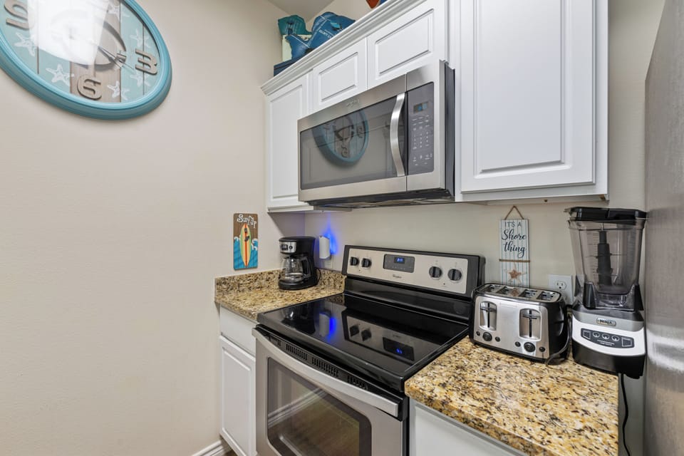 Prepare meals in a sleek, modern kitchen featuring white cabinetry, clean lines, and everything you need for a comfortable cooking experience.