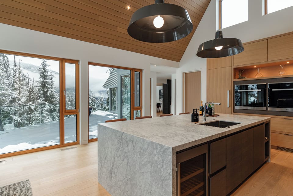 The open kitchen and living area with luxury marble countertops and stunning mountain views.