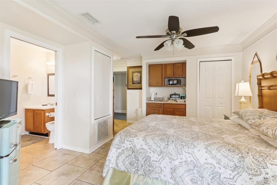 - Bright bedroom with queen bed, patterned bedding, and ceiling fan for comfort  
- Kitchenette with microwave and fridge lets you enjoy added convenience  
- Ensuite bathroom access makes this space functional and private  
