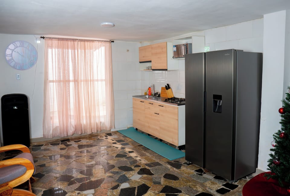 Open kitchen with gas range, refrigerator, microwave and fully stocked kitchen