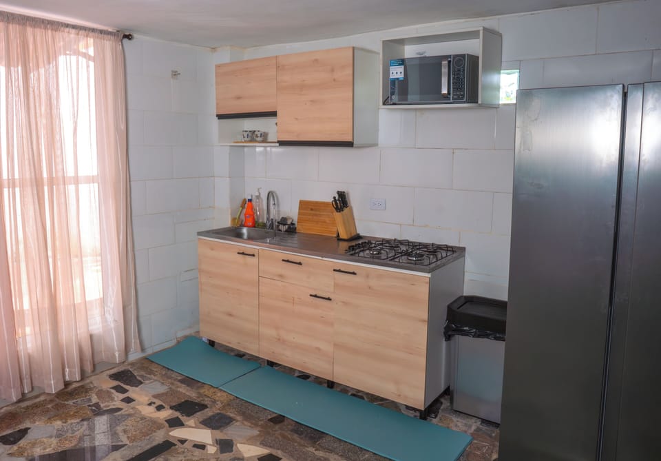 Open kitchen with gas range, refrigerator, microwave and fully stocked kitchen