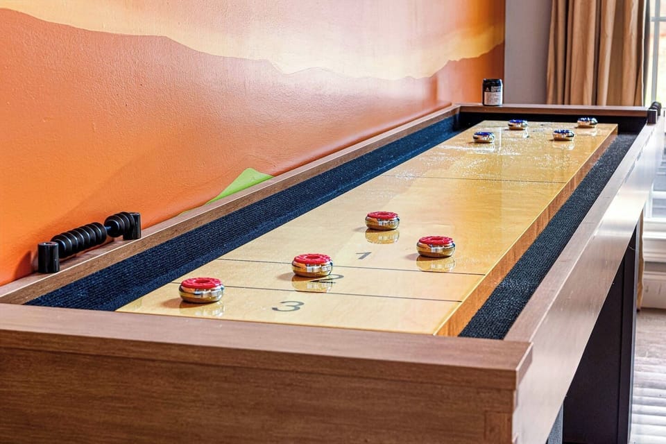 Unwind and challenge friends to a game of shuffleboard in the comfort of this stylish living room. A perfect mix of entertainment and relaxation.