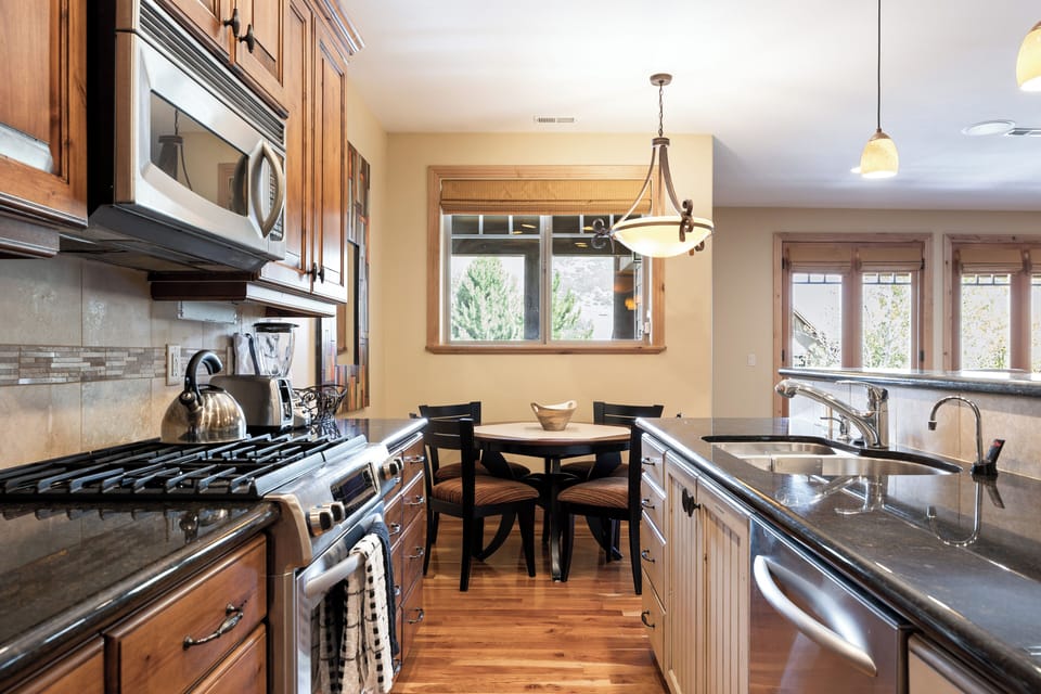 - Cook in a fully equipped kitchen with stainless steel appliances  
- Granite counters and wood cabinetry add warmth and function  
- Dining nook by the window offers natural light and views
