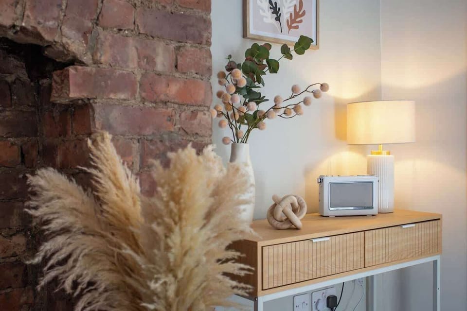 The arrangement of pampas grass in the foreground adds a natural, bohemian touch, creating a warm and inviting atmosphere. 
