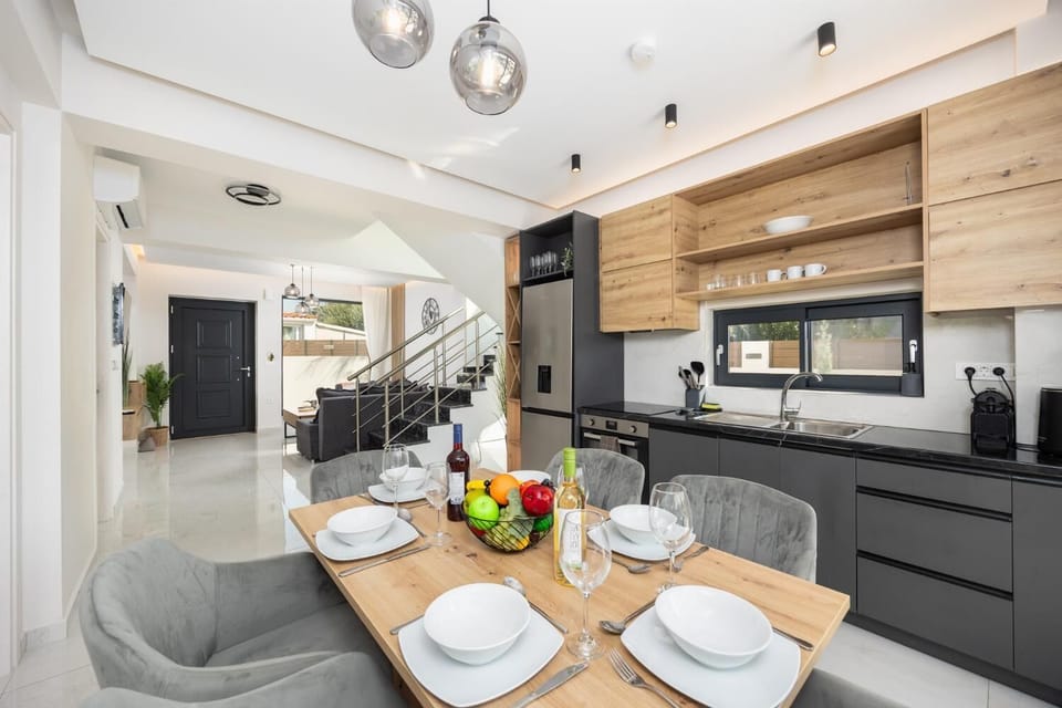 Open-plan living room with sofa, dining area, kitchen, A/C, WiFi internet, and satellite TV