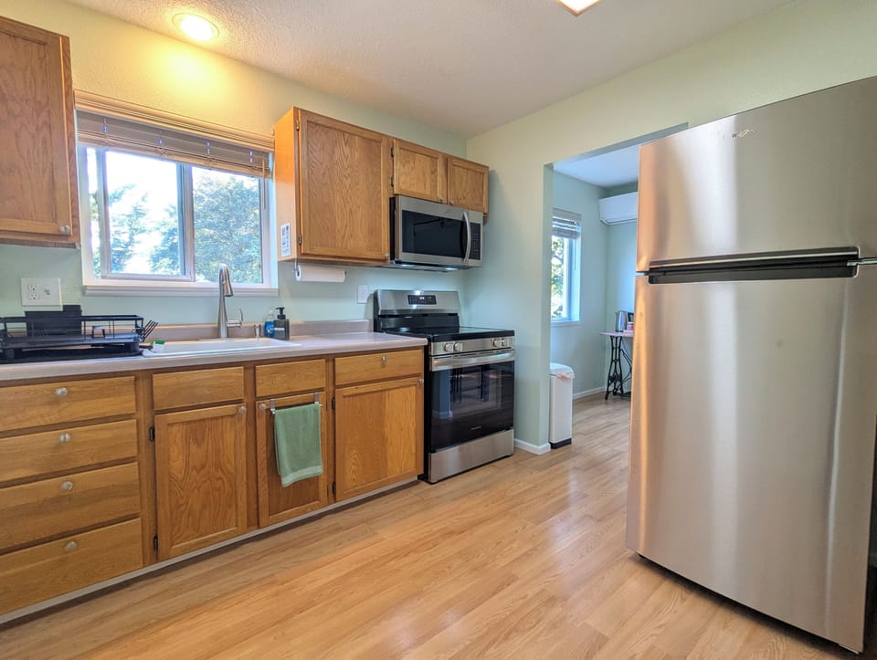 Kitchen with new stove, microwave, and refrigerator.