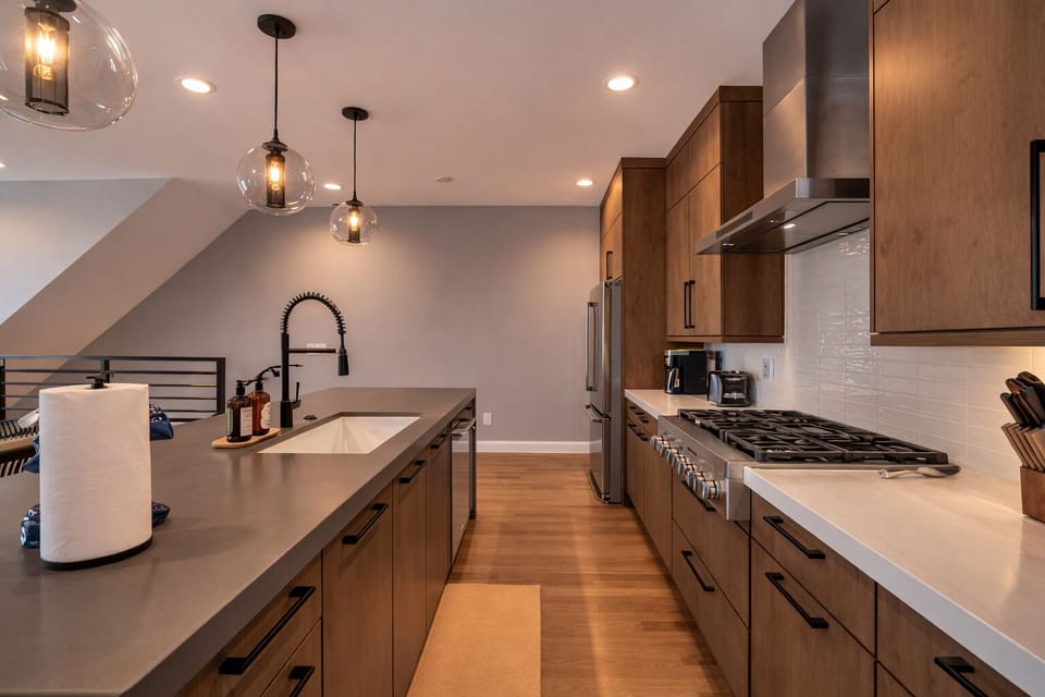 Prepare memorable meals in this beautifully appointed kitchen featuring quartz countertops, stainless steel appliances, generous prep space, and an oversized island perfect for conversation and casual dining.