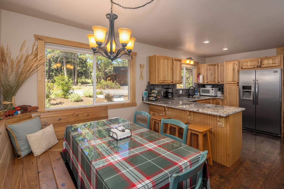 Cedarwood - Bright dining nook w/ cushioned bench seating beside a fully equipped kitchen