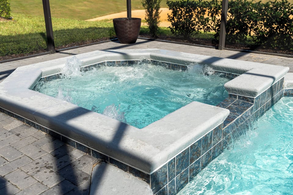Relax in the spacious hot tub surrounded by elegant stone and shimmering tiles, where gentle bubbles and natural light create a refreshing atmosphere for your perfect getaway.