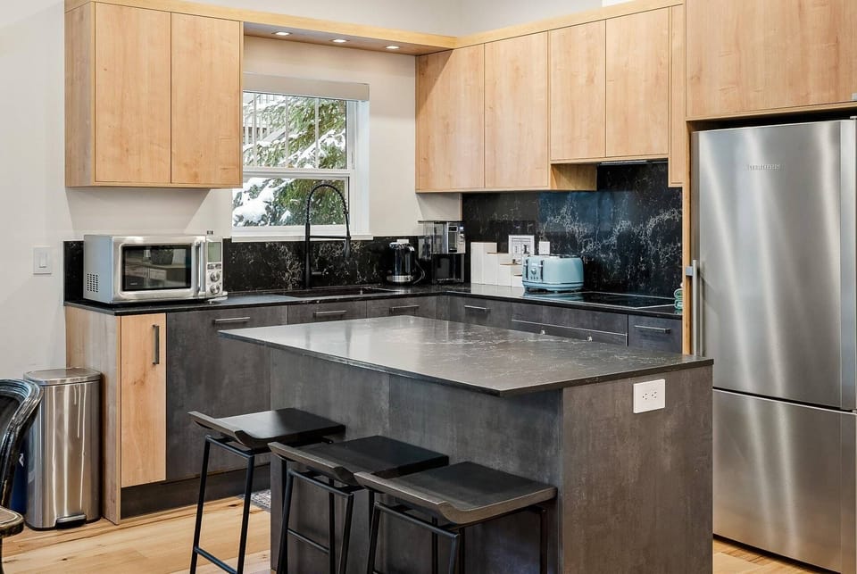Custom kitchen with spacious island, undermounted lighting and full size appliances