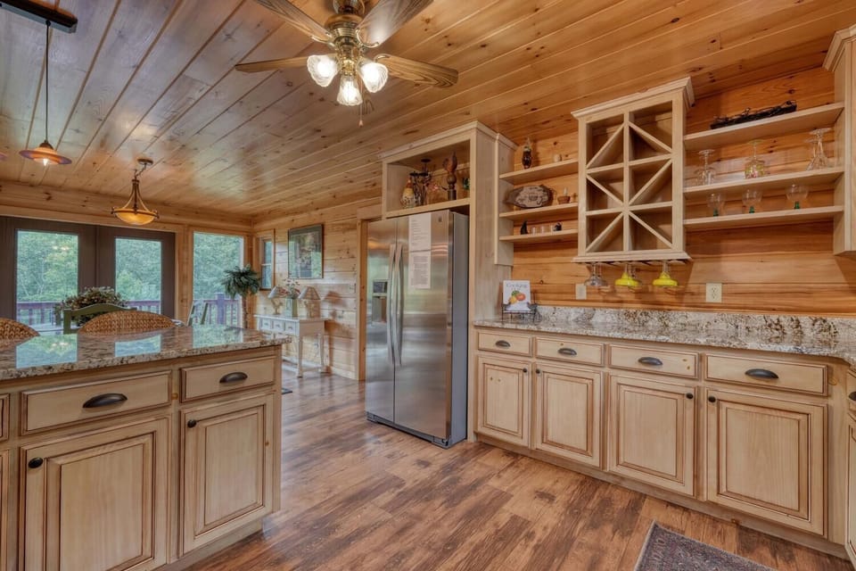 "Bright kitchen with island seating, views, and sleek stainless appliances."