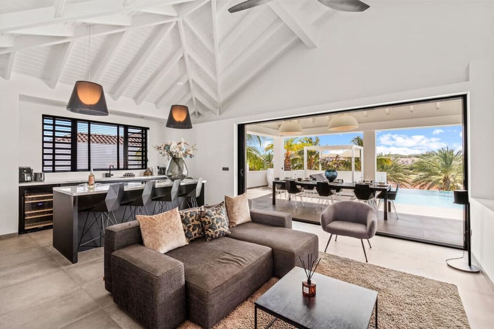 Open-concept living at its finest — cook, lounge, and dine with a seamless view of the pool and tropical greenery. Perfect spot for laid-back mornings or sunset dinners with a breeze.