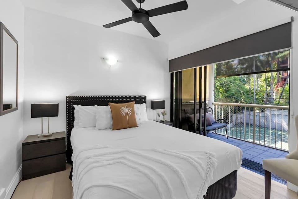 The second bedroom has direct access to the balcony, set with a plush queen-sized bed.
