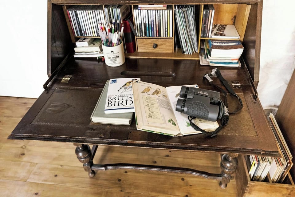 Writing bureau with CDs, binoculars and bird books