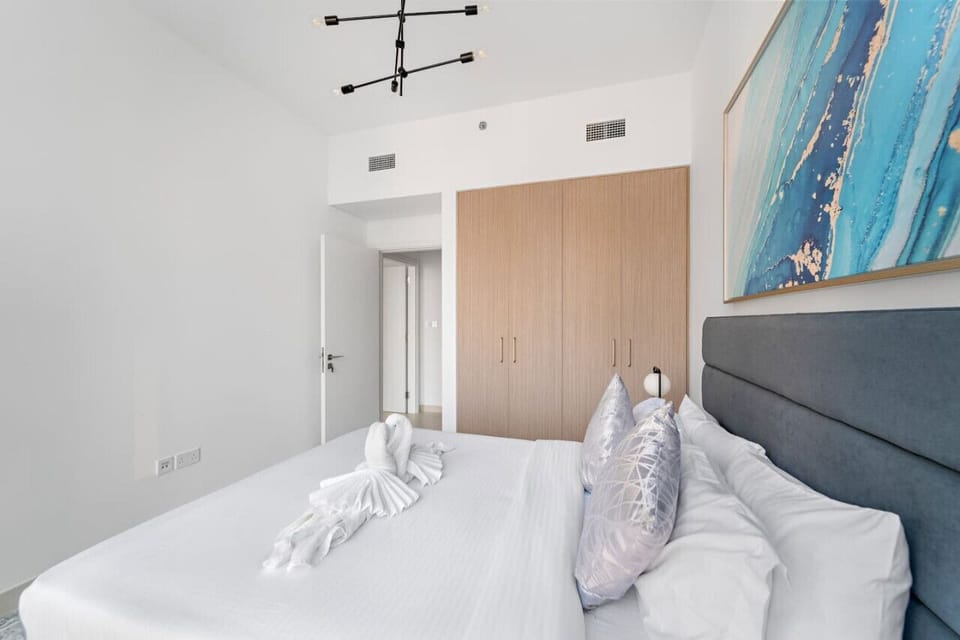 Bedroom Retreat: Modern design meets comfort with plush pillows and vibrant art for restful nights!