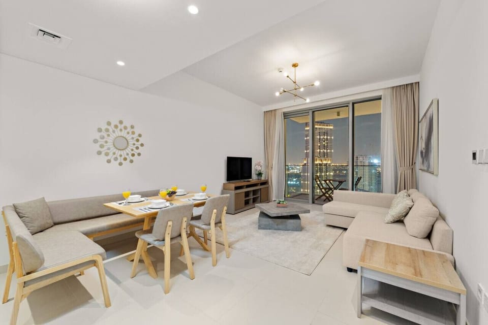 A cozy living room with a dining area, city views, and soft furniture.