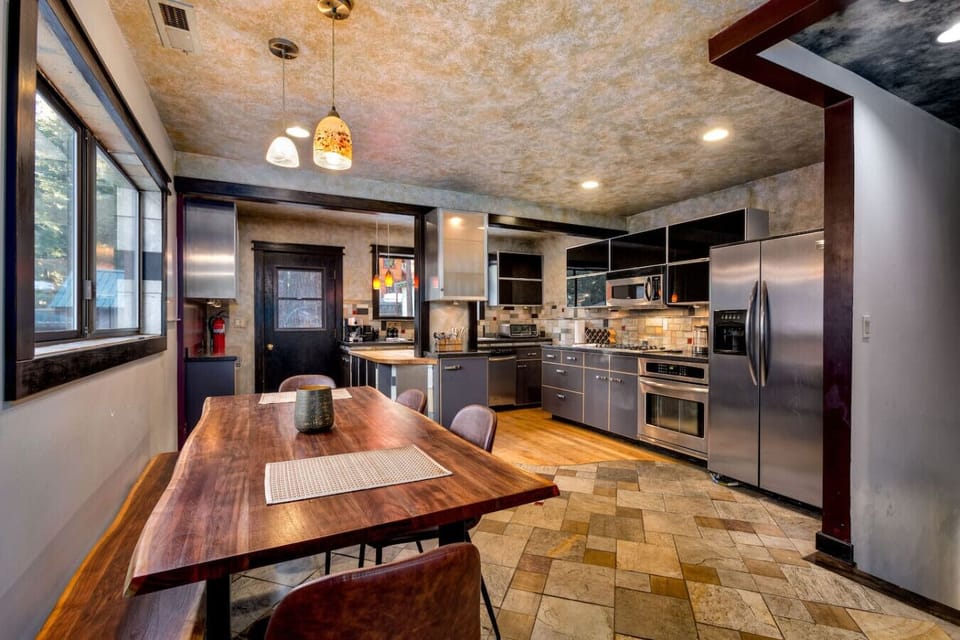 A kitchen made for gatherings, with a beautiful dining table and modern appliances.